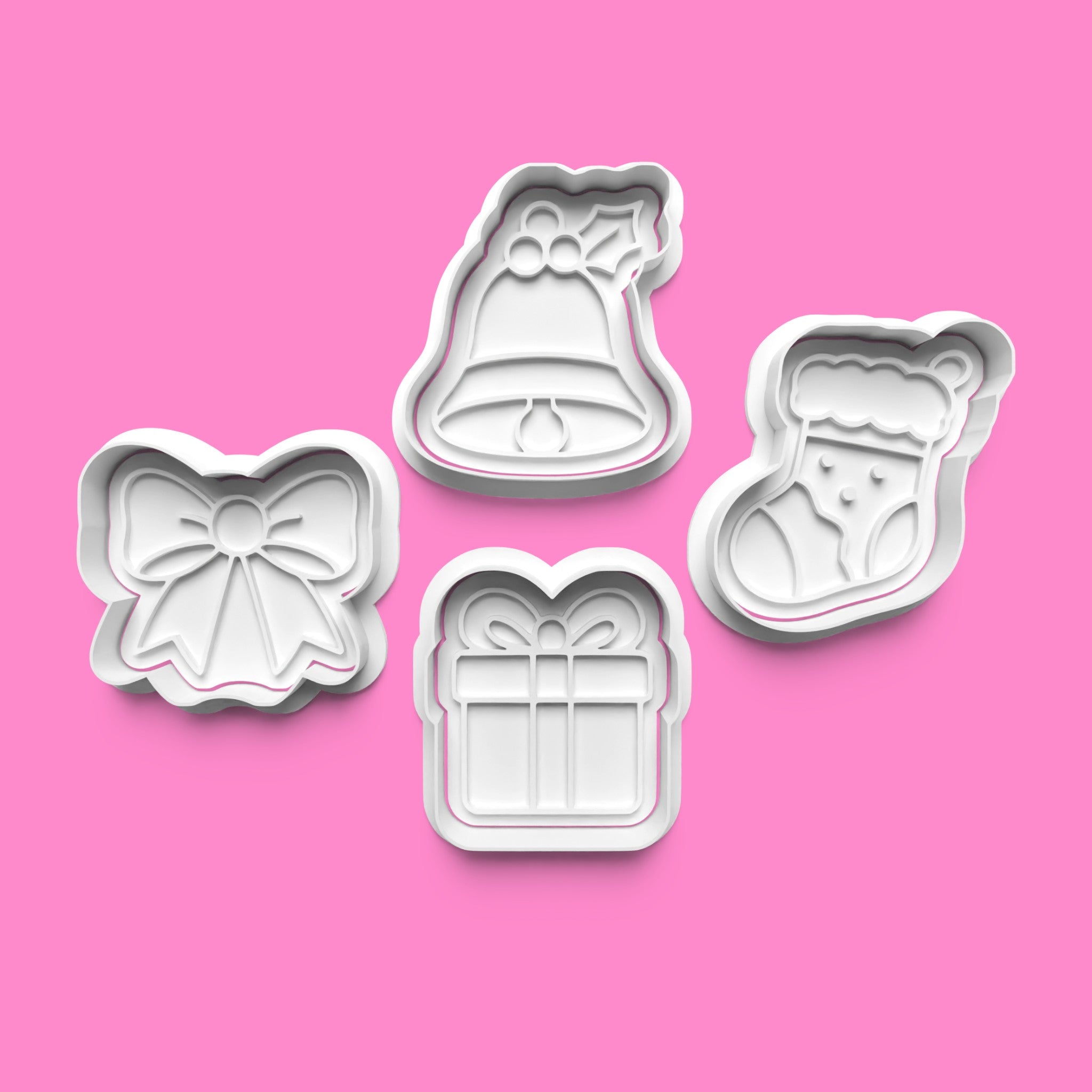 Set of Christmas-themed cookie cutters on a pink background