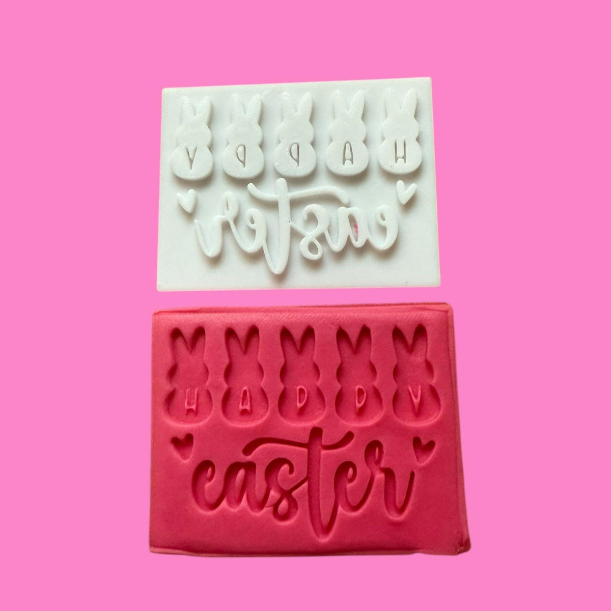 An image showing a cookie cutter and stamp set with 'HAPPY EASTER' lettering in the shape of bunnies, with one half showing the cutter outline and the other half showing the embossed stamp.