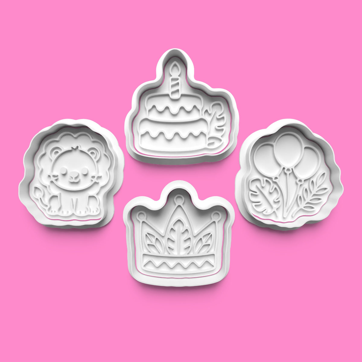 Four white 3D printed birthday cookie cutters and embossers featuring a cute lion, birthday cake, balloons and crown on a black background.