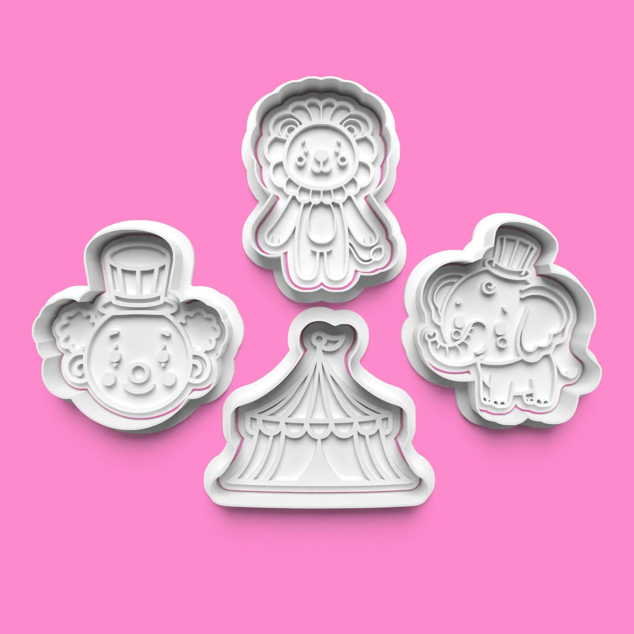 A set of circus-themed cookie cutters and stamps, including shapes for clowns, tents, animals, and tickets.