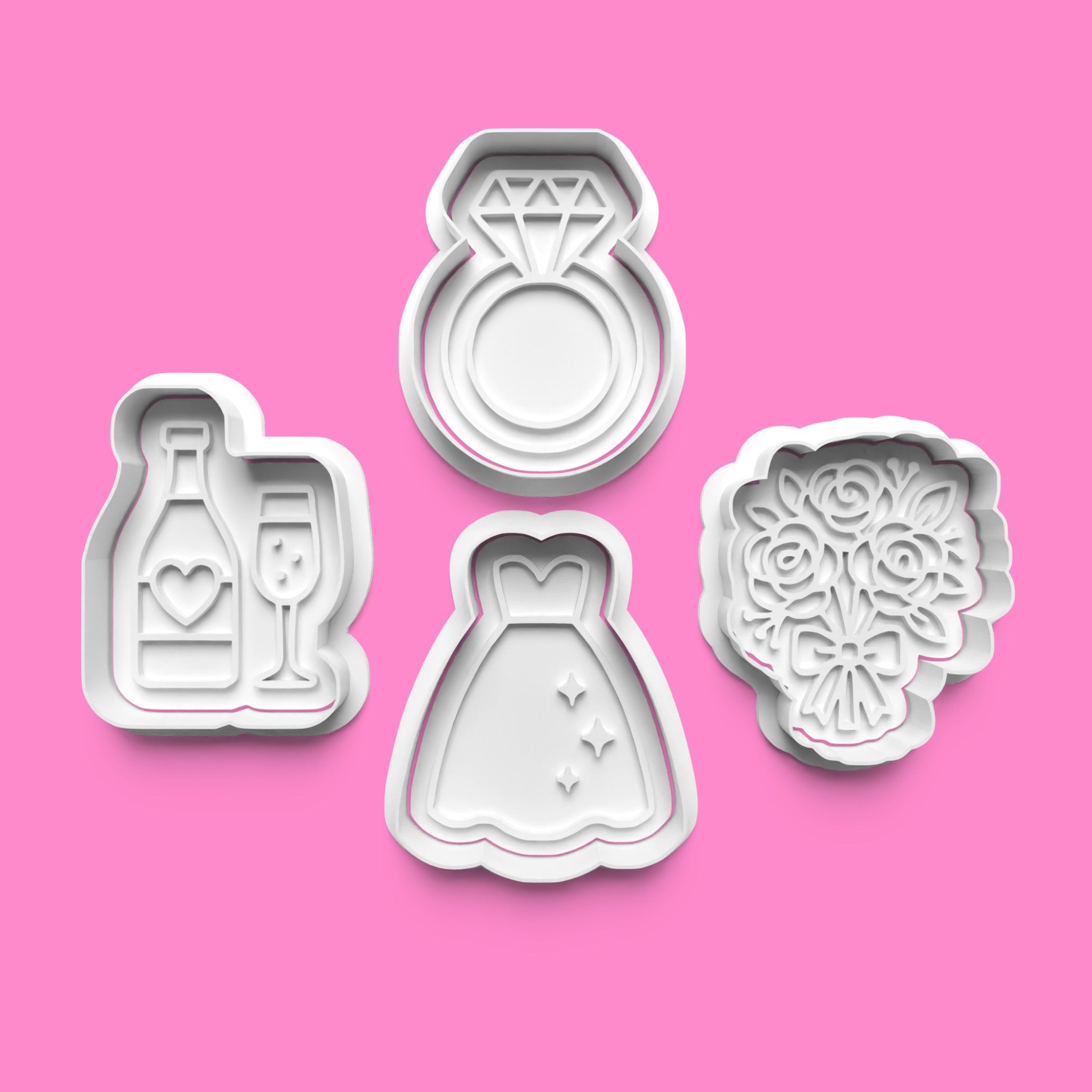 Set of four cookie cutters shaped like a diamond ring, wedding dress, bouquet, and champagne bottle on a pink background.