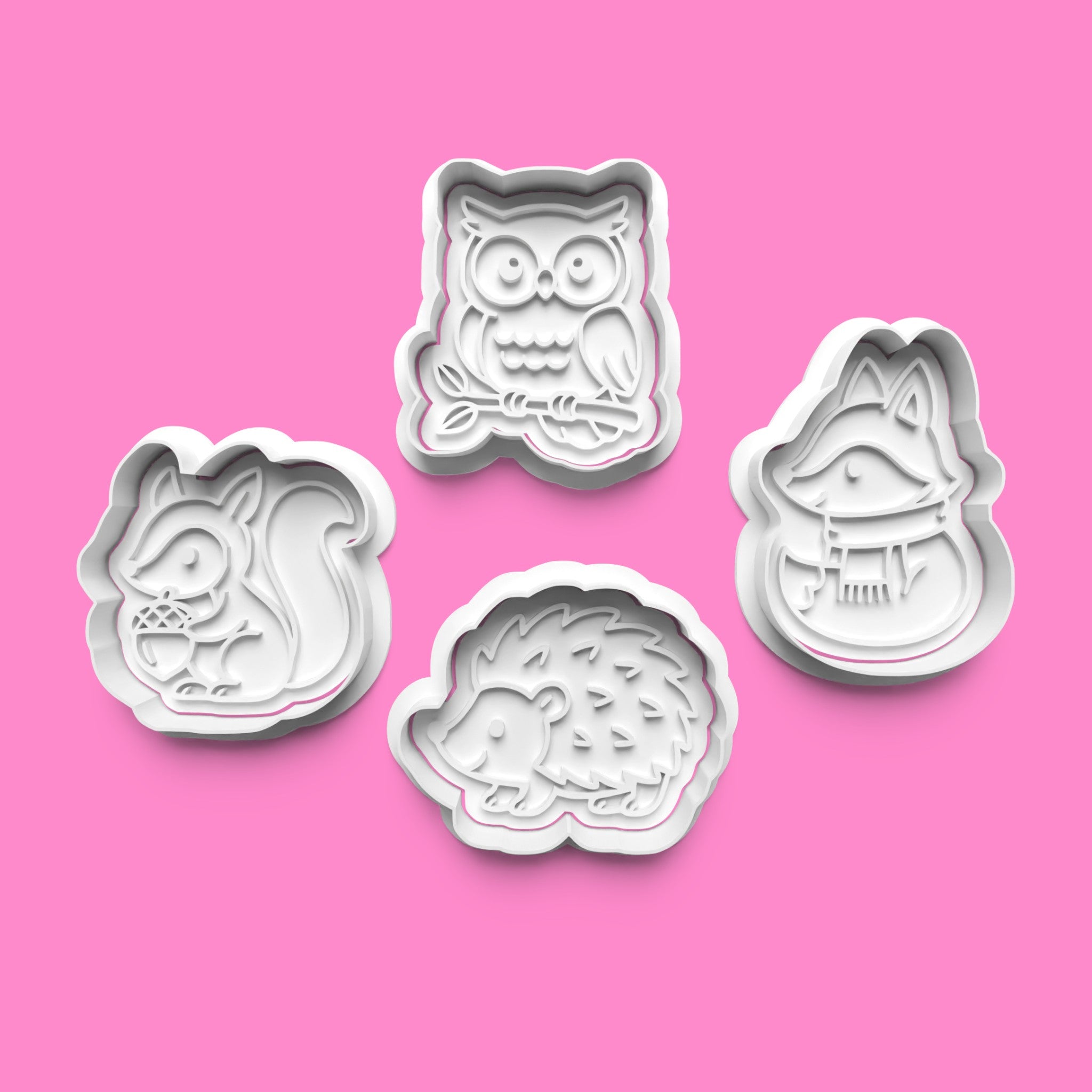 Set of four animal-themed cookie cutters on a pink background
