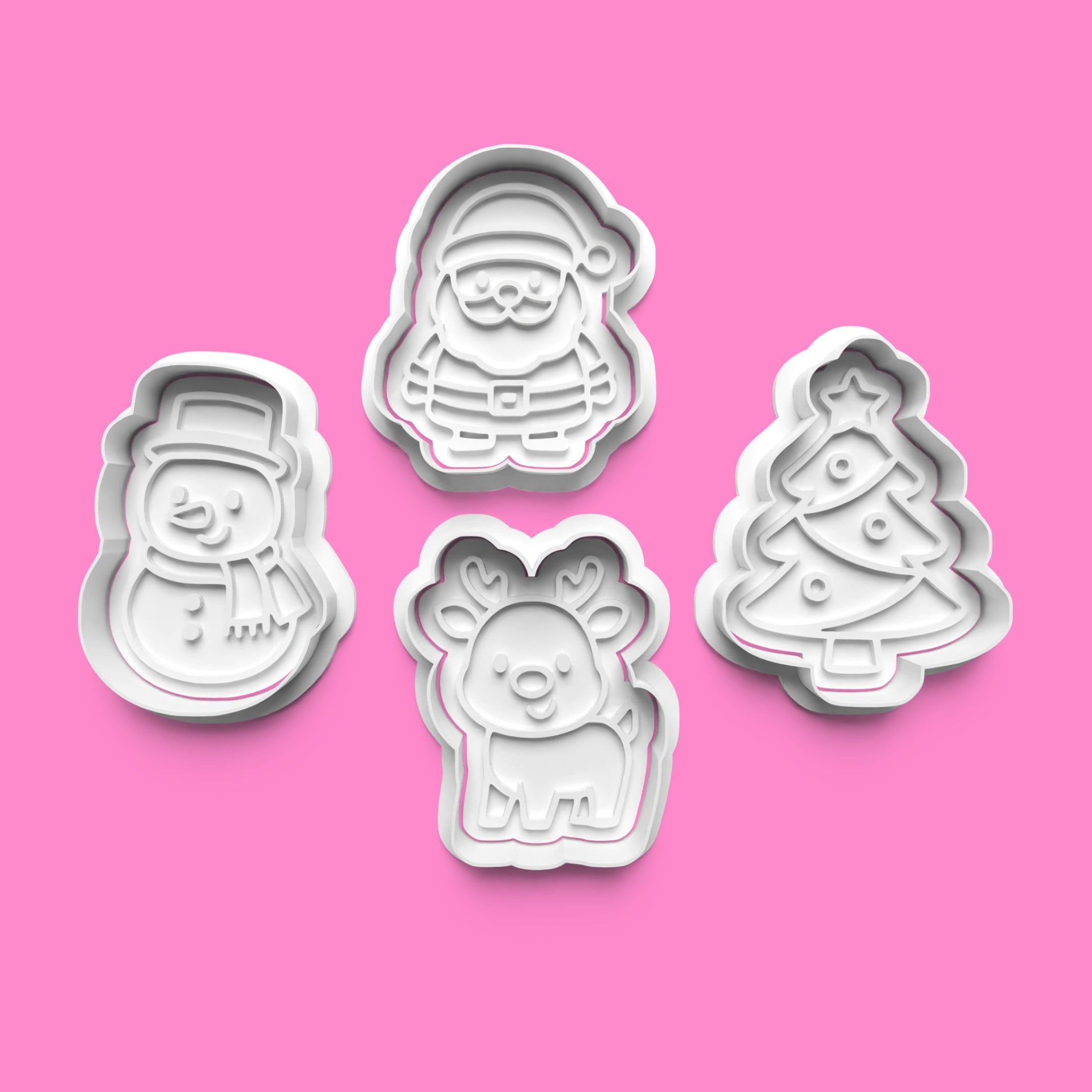 Set of Christmas-themed cookie cutters on a pink background