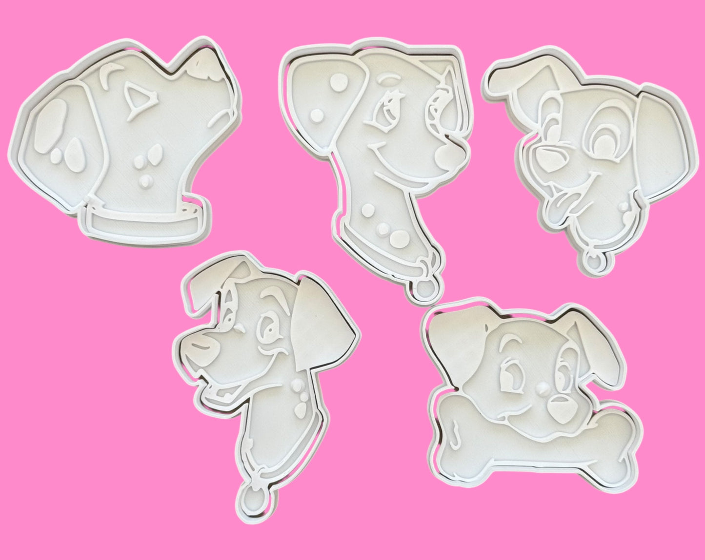 Set of five dog-themed cookie cutters on a pink background