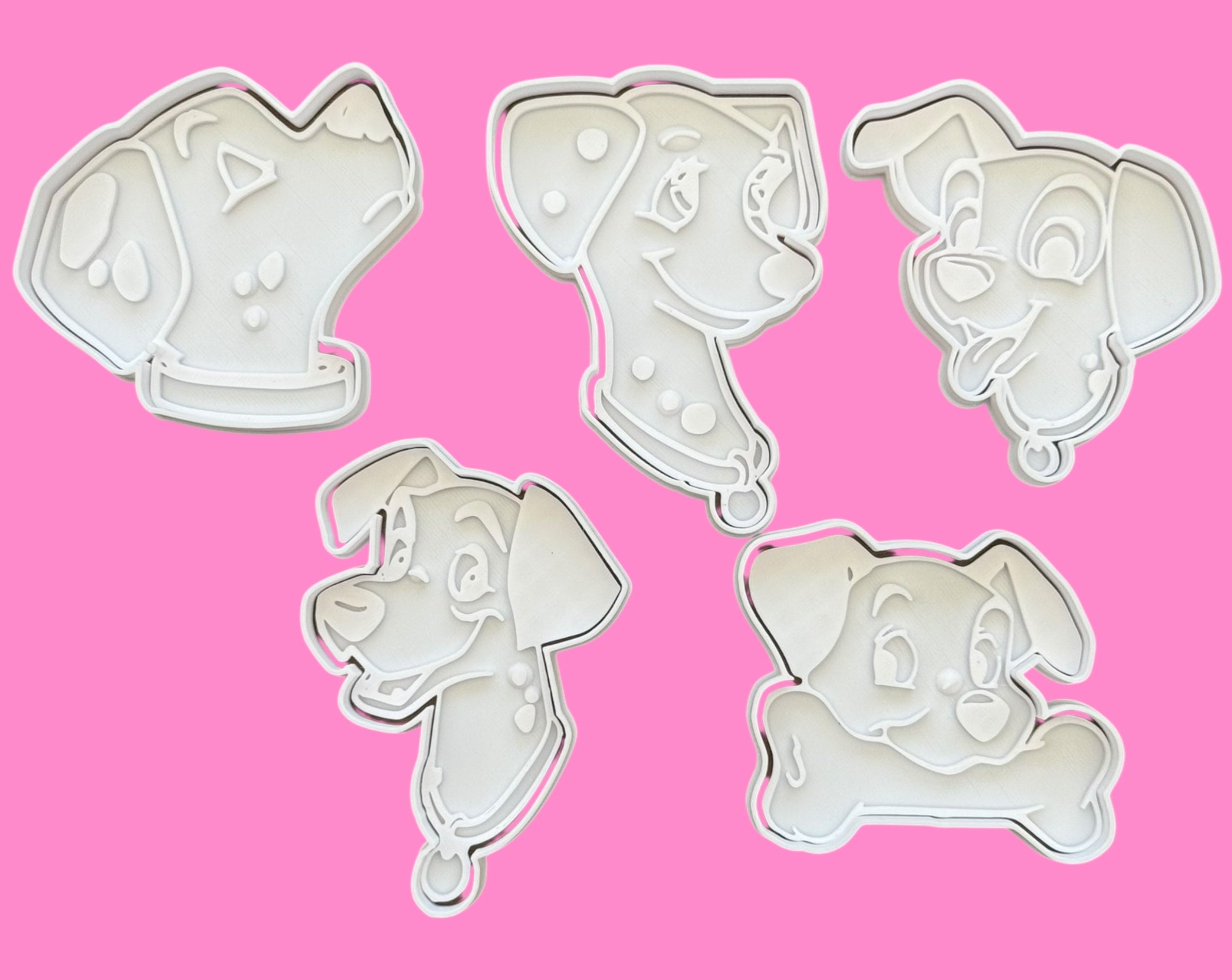 Set of five dog-themed cookie cutters on a pink background
