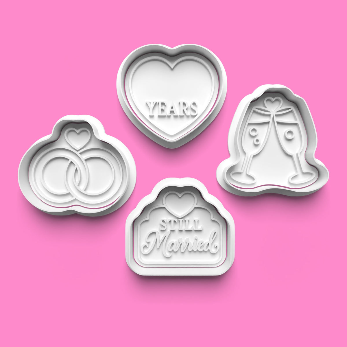 Wedding anniversary cookie cutter and embosser set of four designs featuring intertwined wedding rings, YEARS heart, champagne glasses and Still Married plaque by Emboss & Impress.