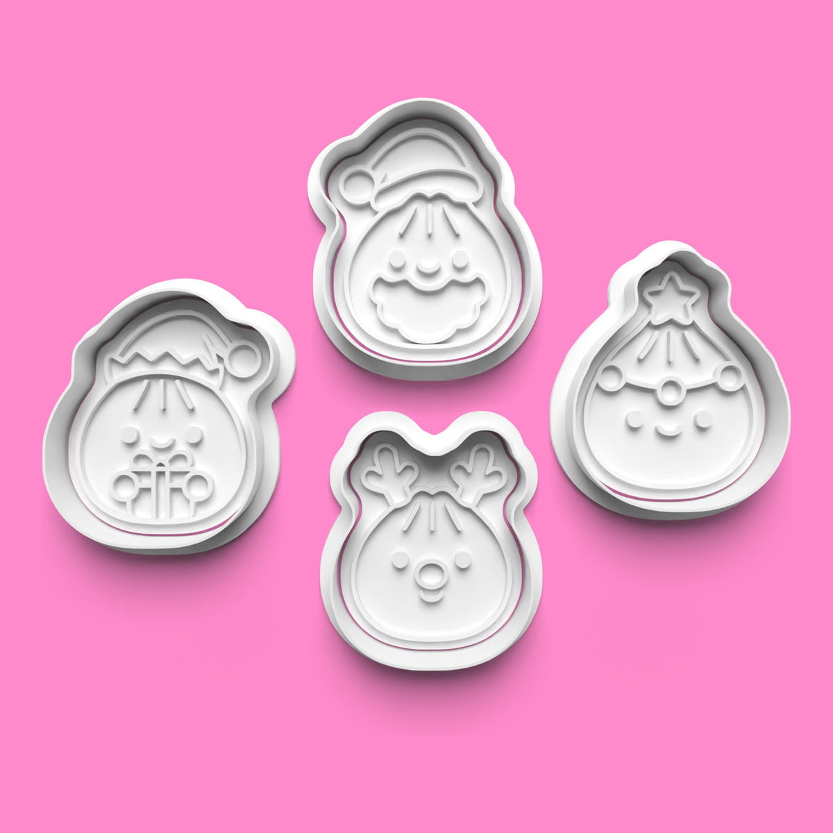 Set of four cute Christmas face cookie cutters and embossers featuring an elf holding a present, Santa Claus, a reindeer and a smiling Christmas character by Emboss & Impress.
