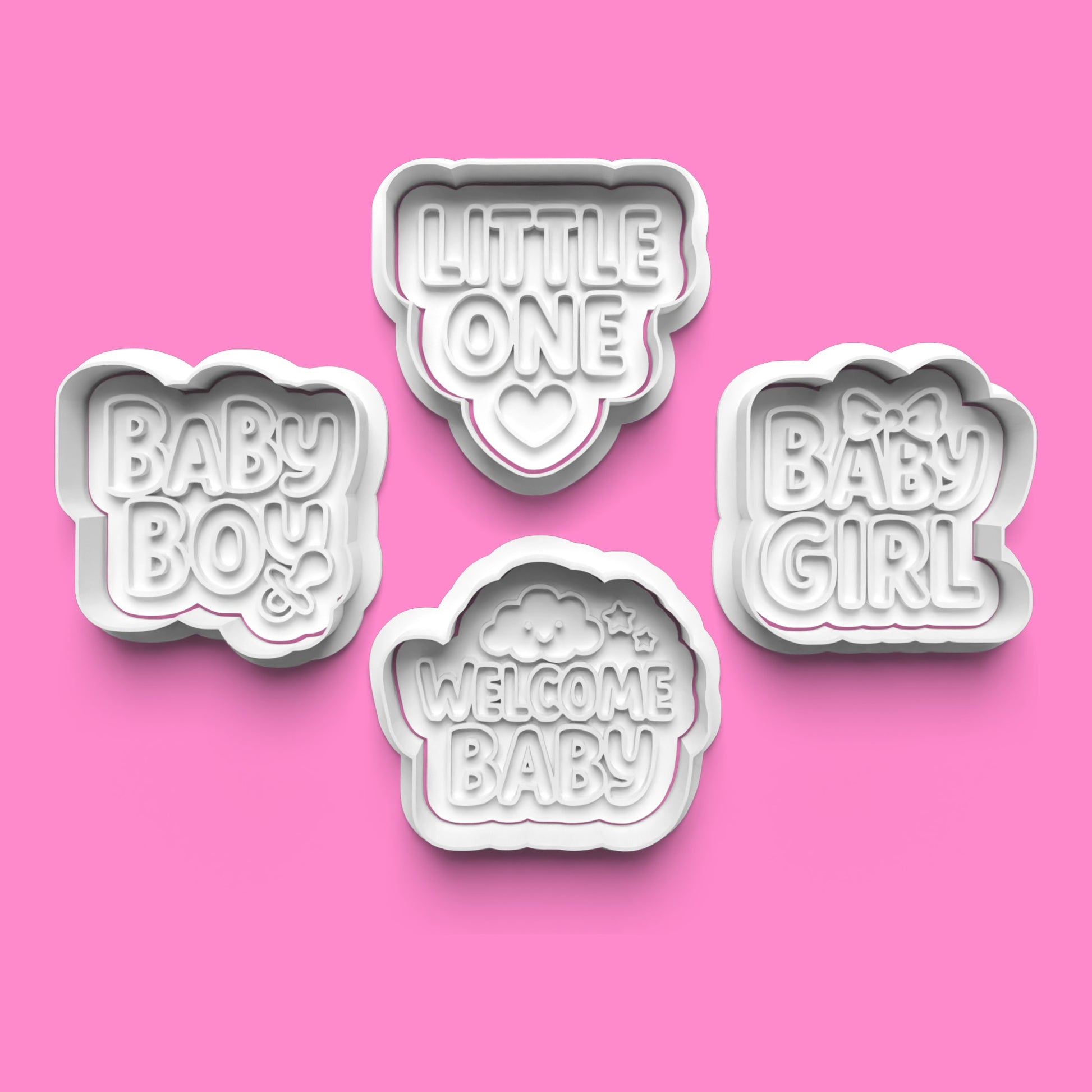 Set of four cookie cutters with baby-themed phrases on a pink background