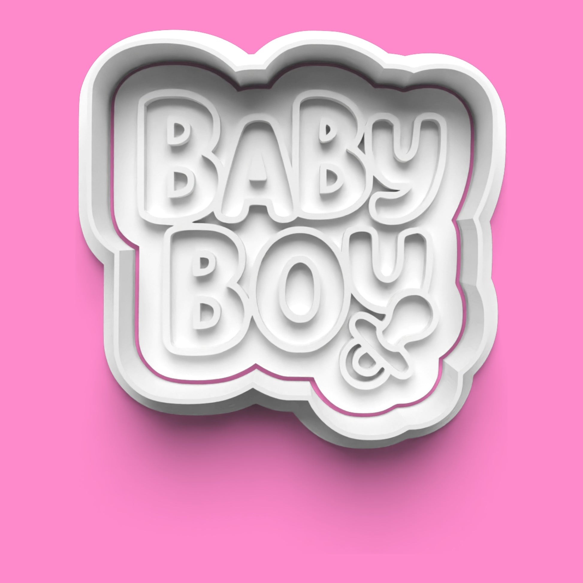 Cookie cutter with 'BABY BOY' text on a pink background