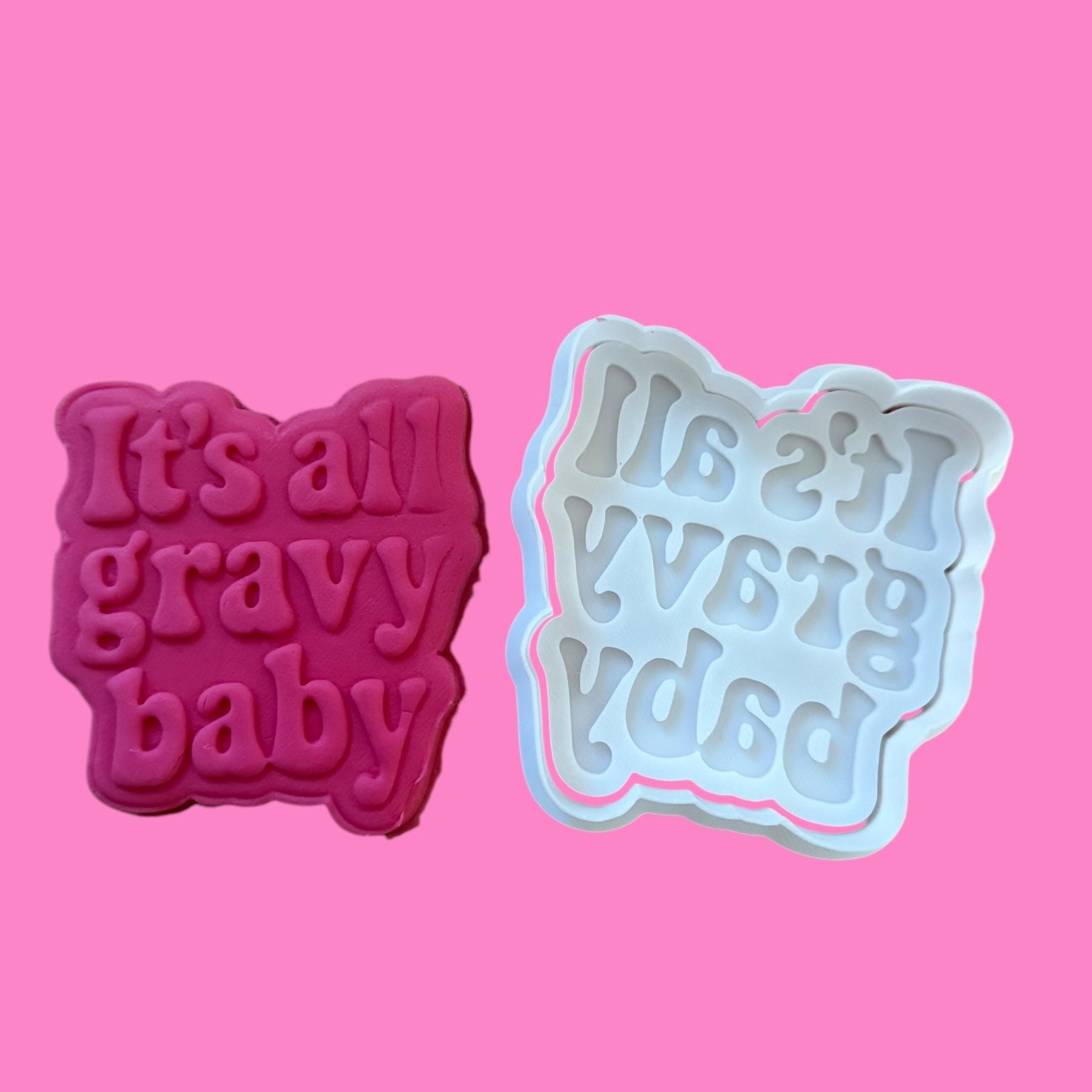 Two cookie cutters with 'It's a gravy baby' text on a pink background