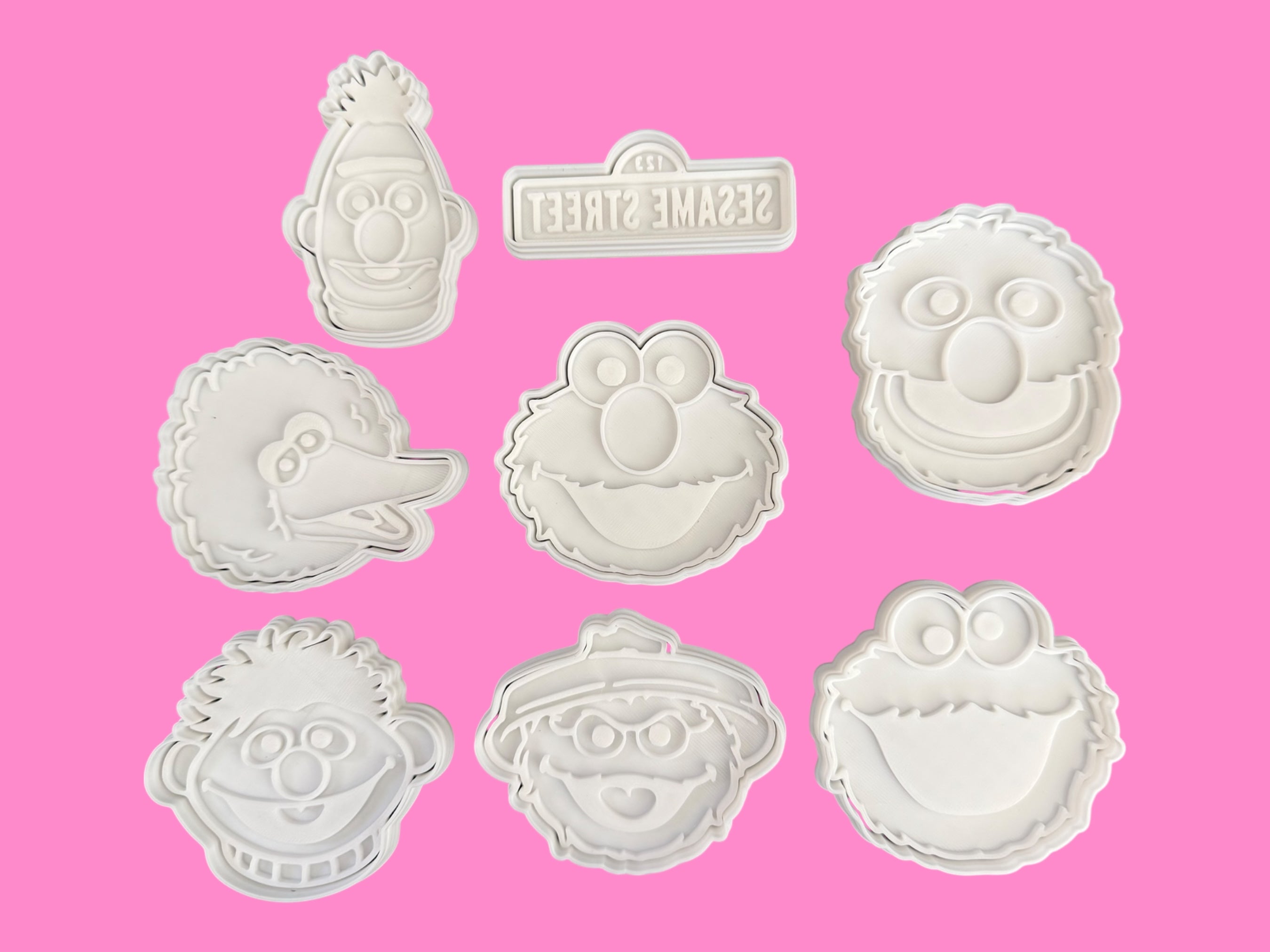 Set of Sesame Street-themed cookie cutters on a pink background