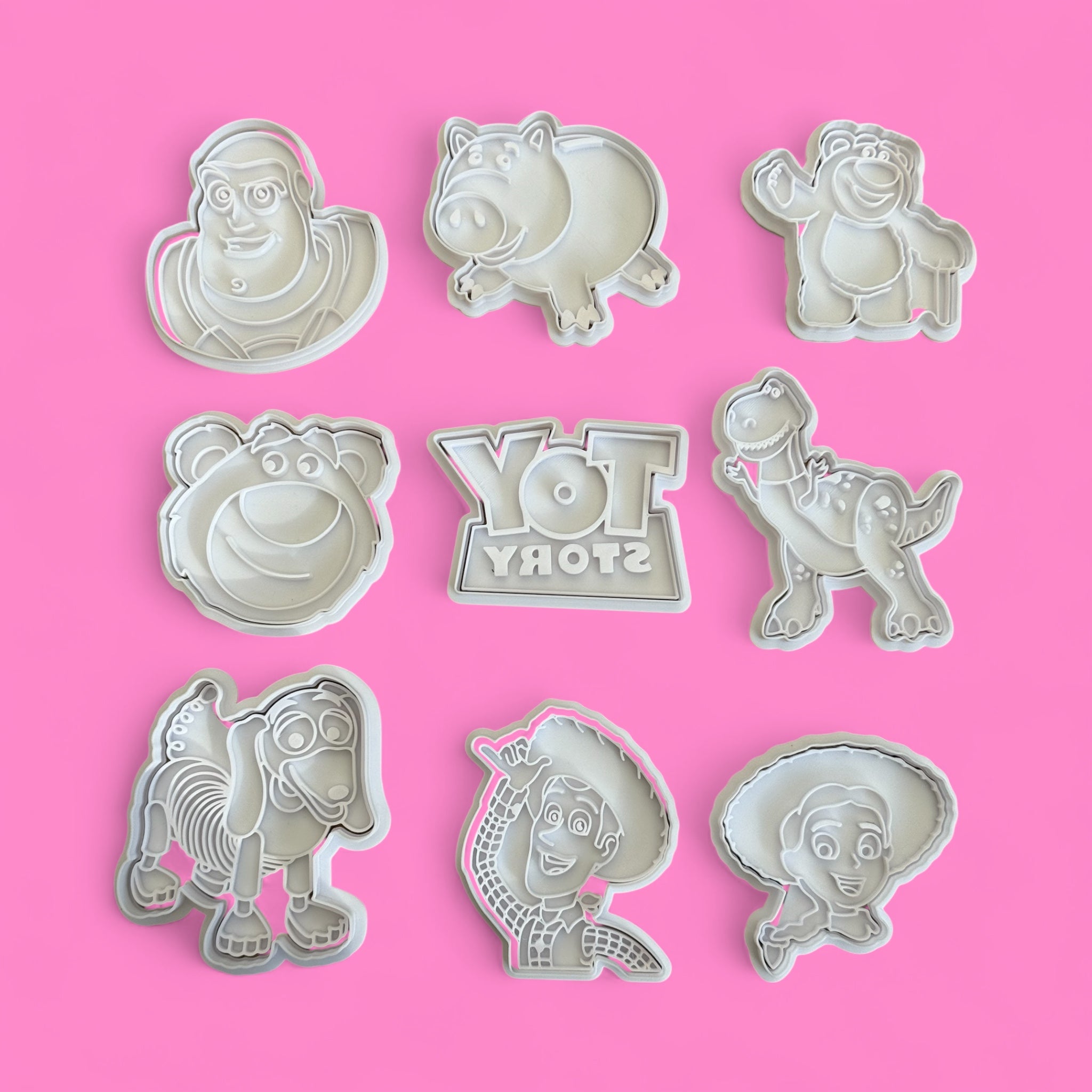 Set of Toy Story-themed cookie cutters on a pink background