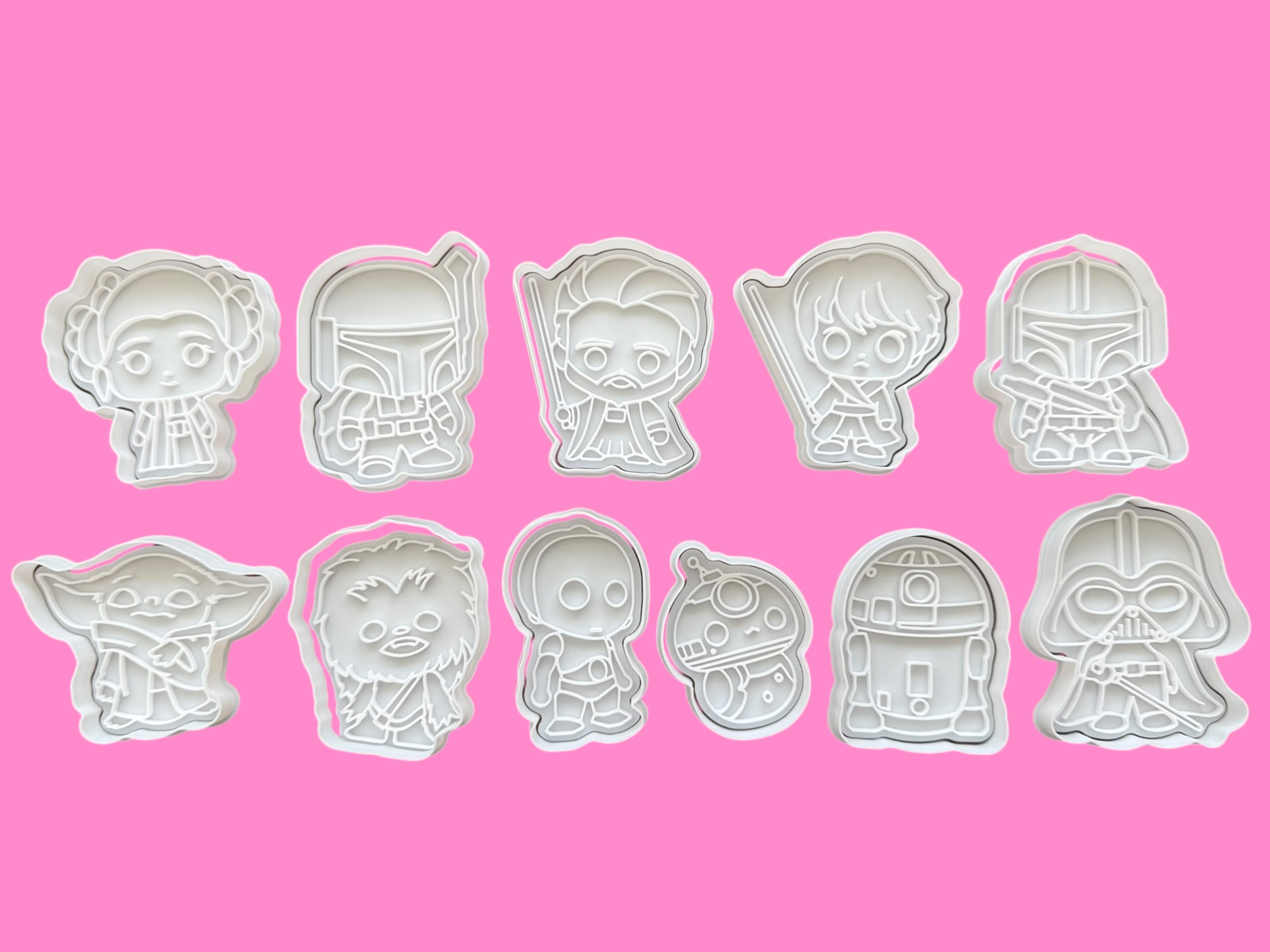 Set of Star Wars-themed cookie cutters on a pink background