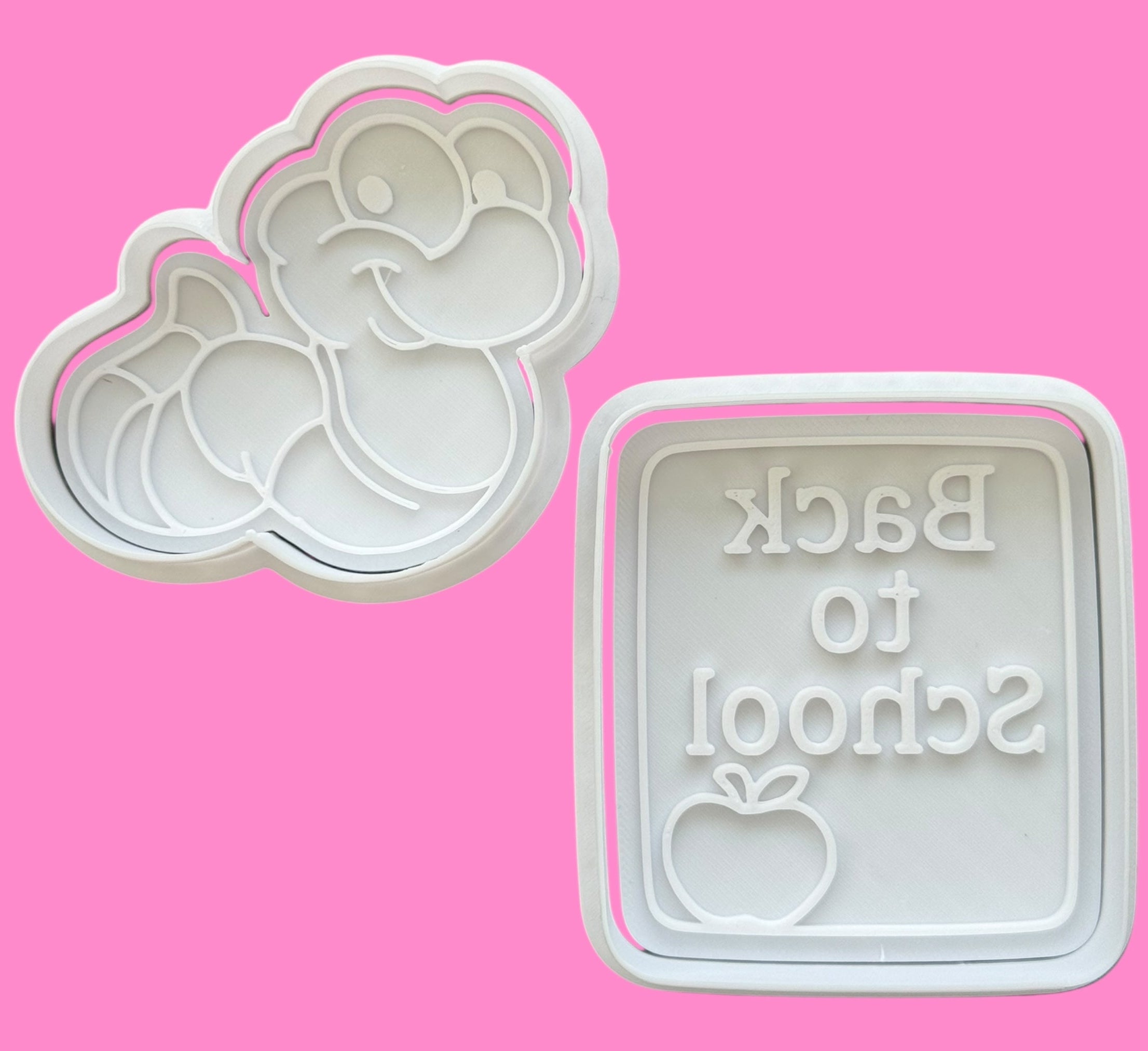 Two cookie cutters on a pink background, one with a floral design and the other with 'Back to School' text.