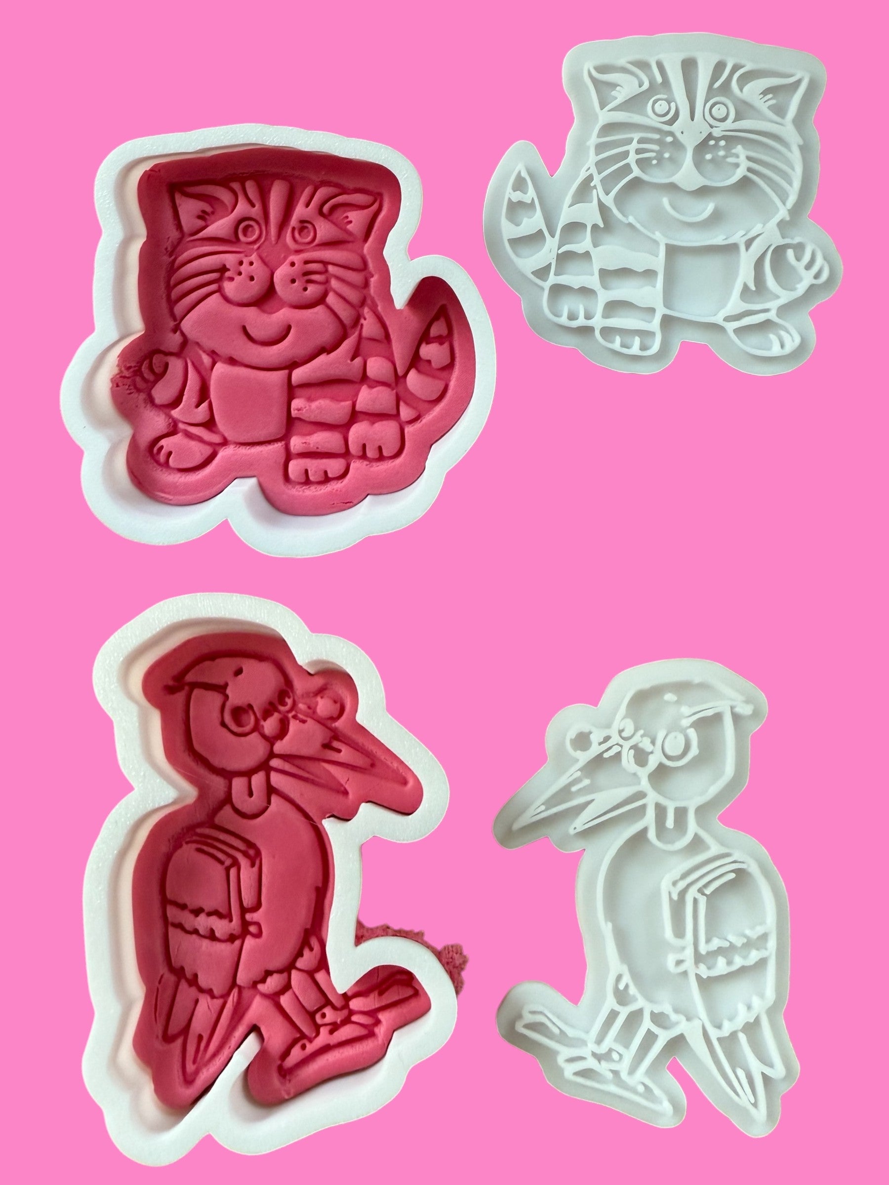 A set of four cookie cutters and embossers in pink and white colors, featuring characters from the Bagpuss & Professor Yaffle series.