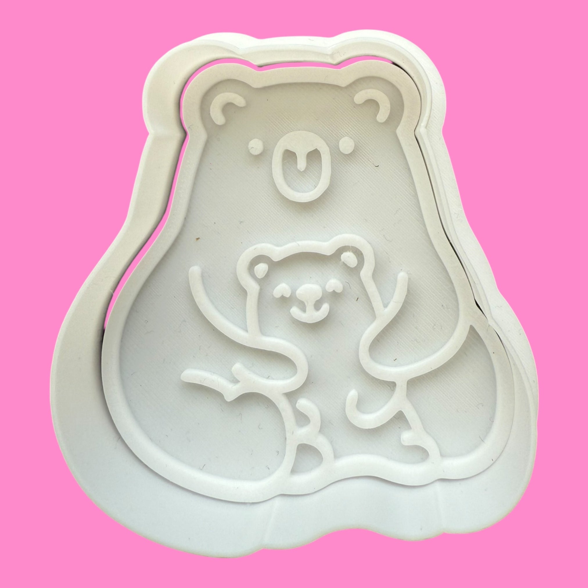 Bear-shaped cookie cutter on a pink background