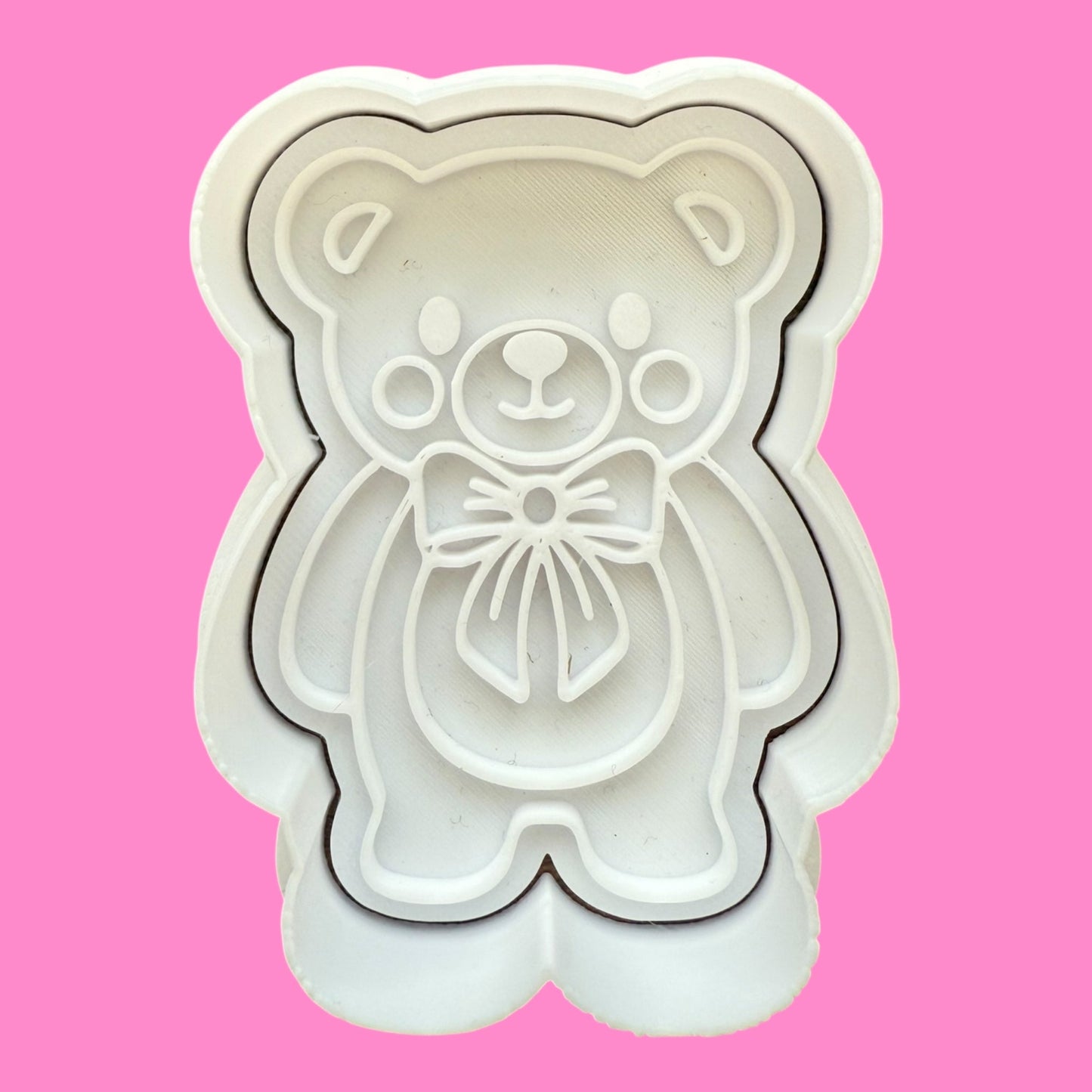 White bear-shaped cookie cutter on a pink background