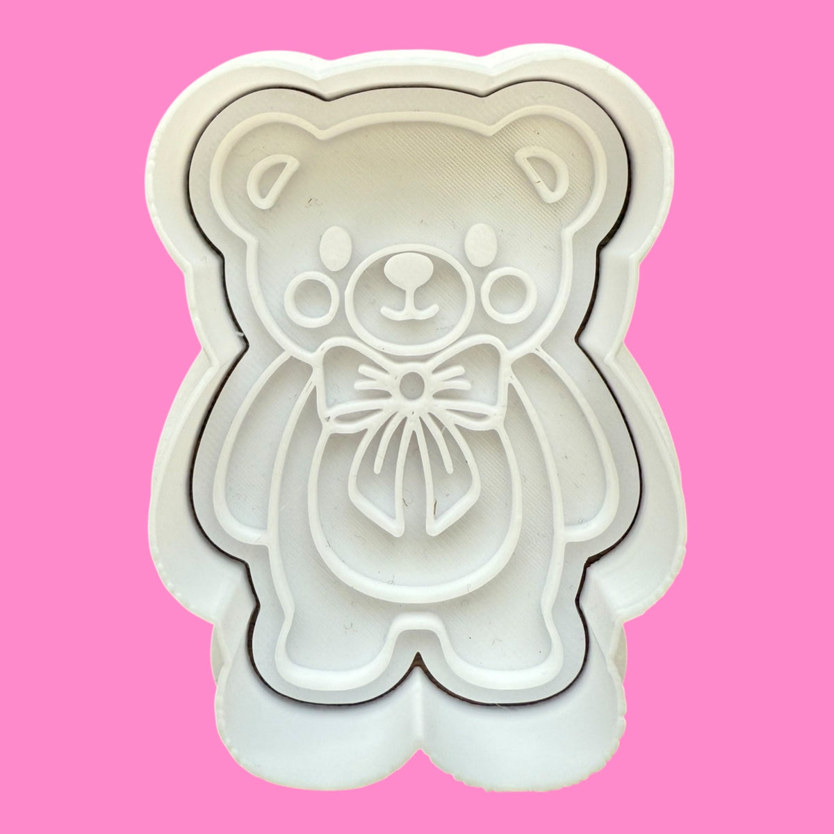White bear-shaped cookie cutter on a pink background