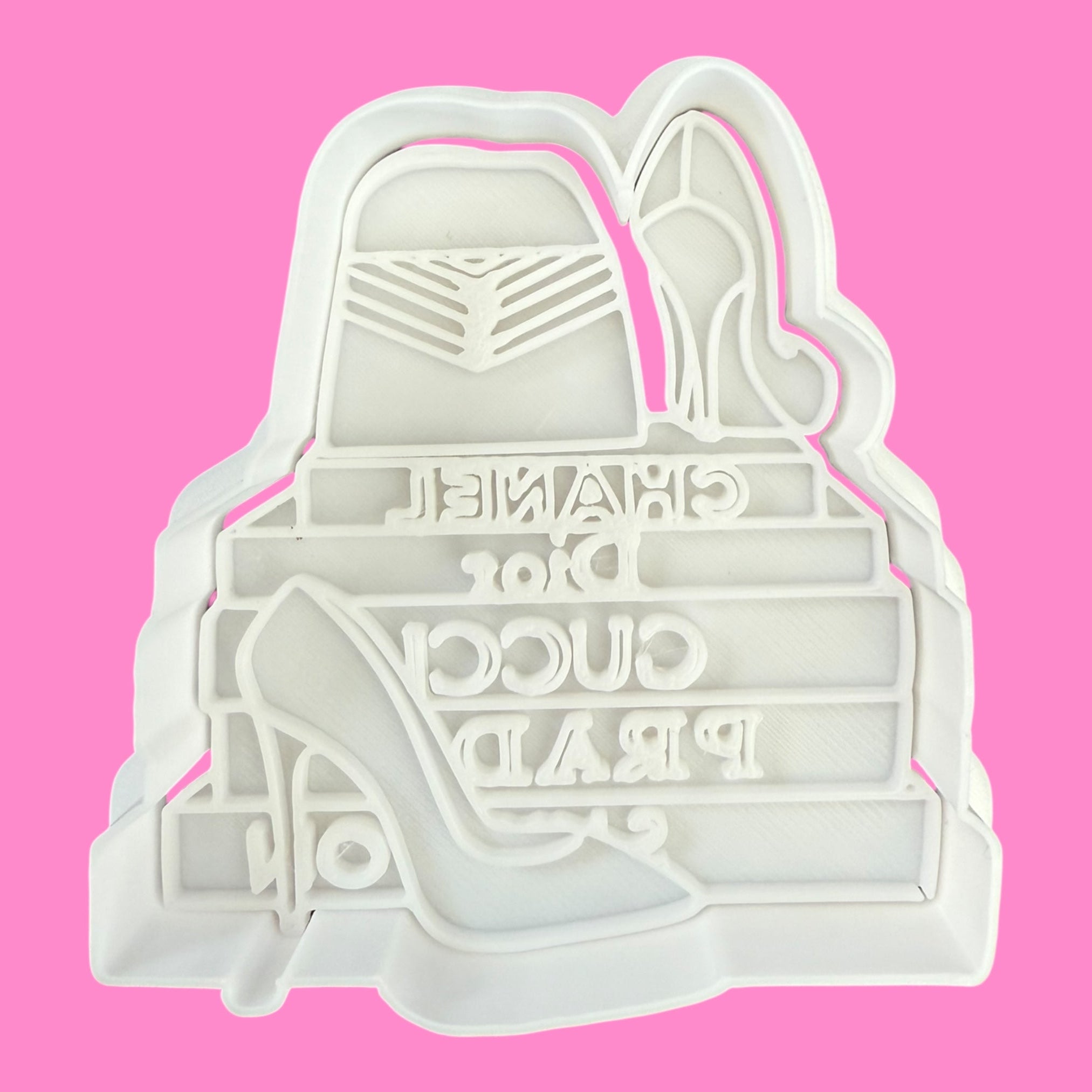 Cookie cutter shaped like a high heel shoe with text on a pink background