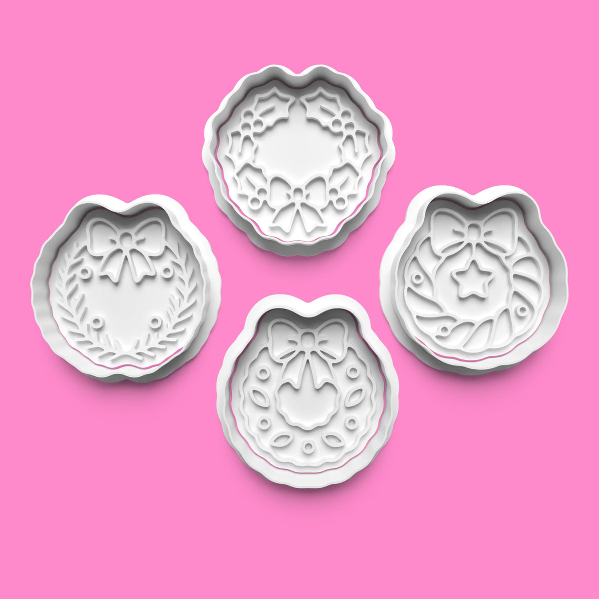 Set of four Christmas wreath cookie cutters and embossers featuring bows, holly, foliage and star designs, available in 7cm, 8cm and 10cm.
