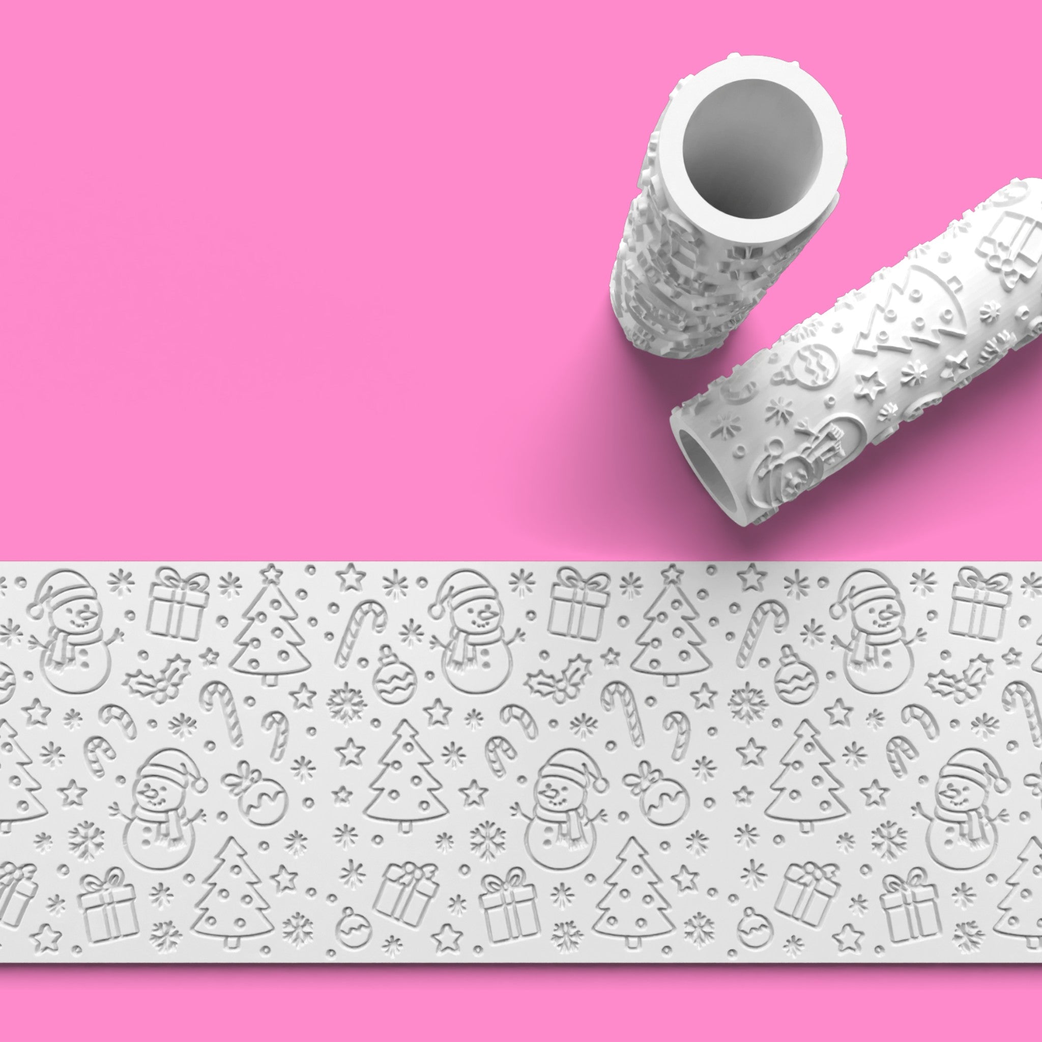 Two embossing rolls with Christmas-themed designs on a pink background