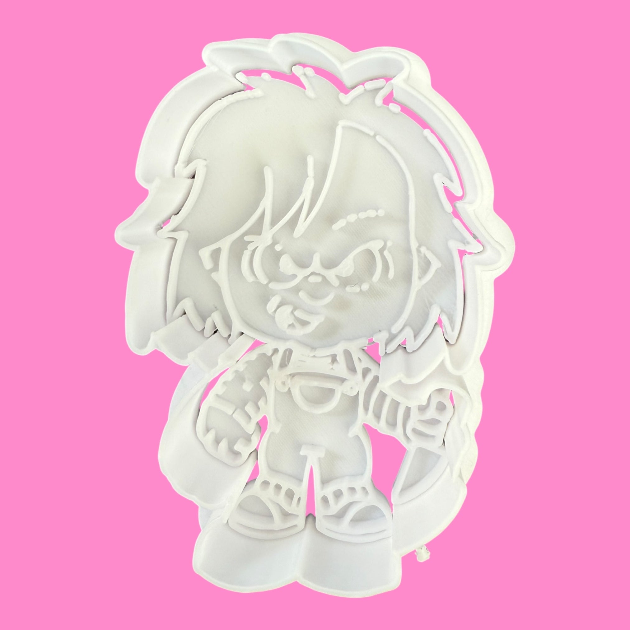 White cookie cutter shaped like a cartoon character on a pink background