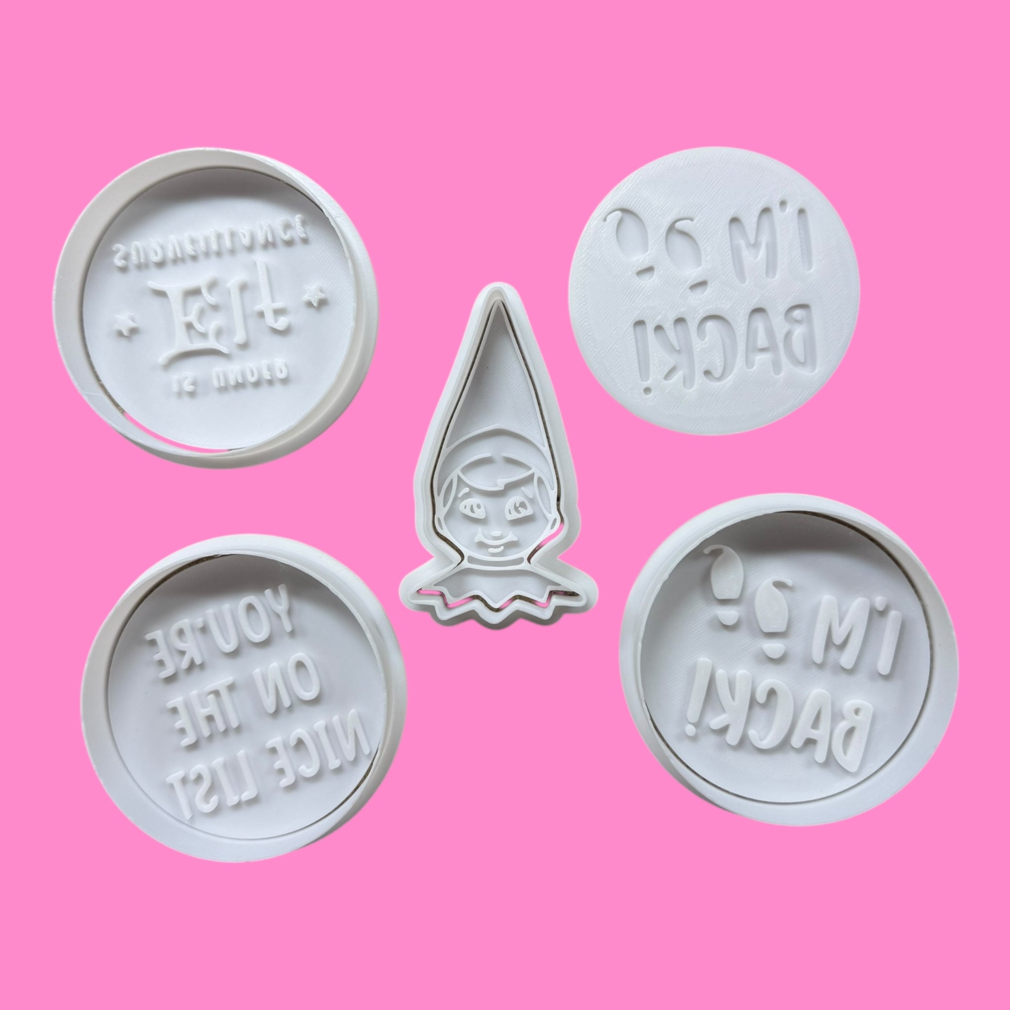 Set of cookie cutters with text and a hooded figure on a pink background