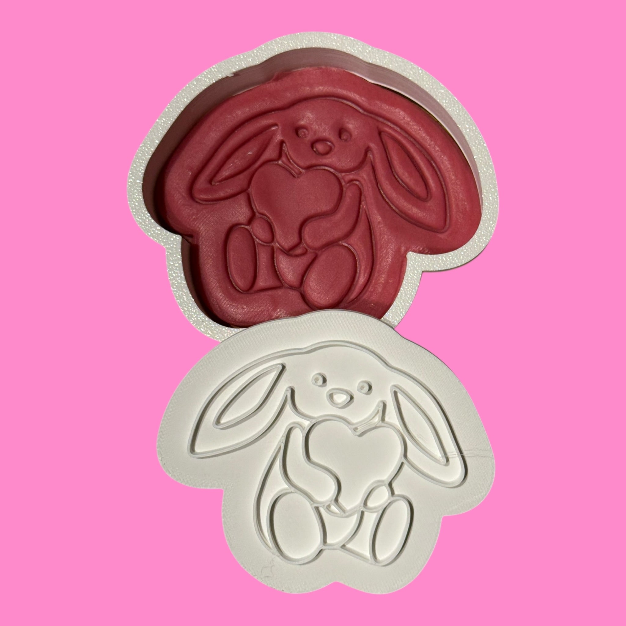 Cookie cutter with a dog design on a pink background