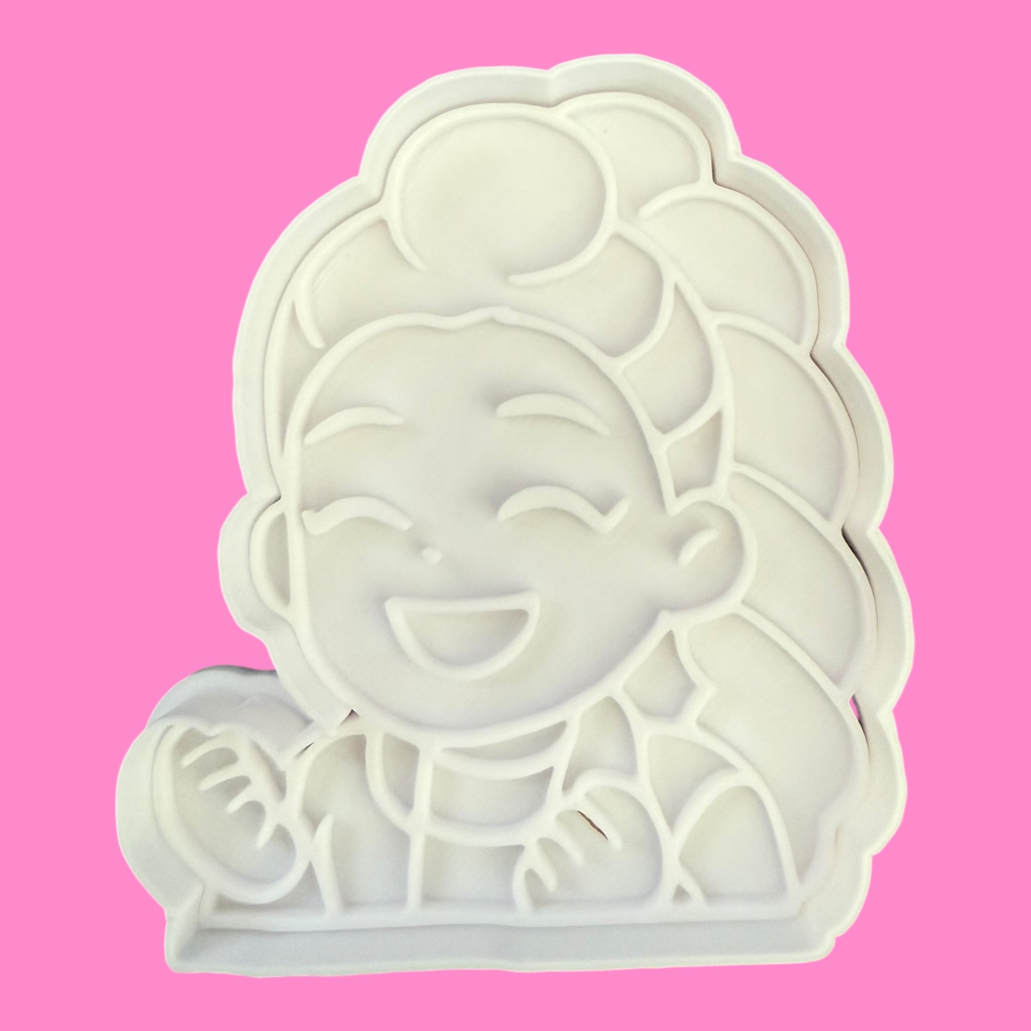 Cookie cutter shaped like a cartoon character on a pink background