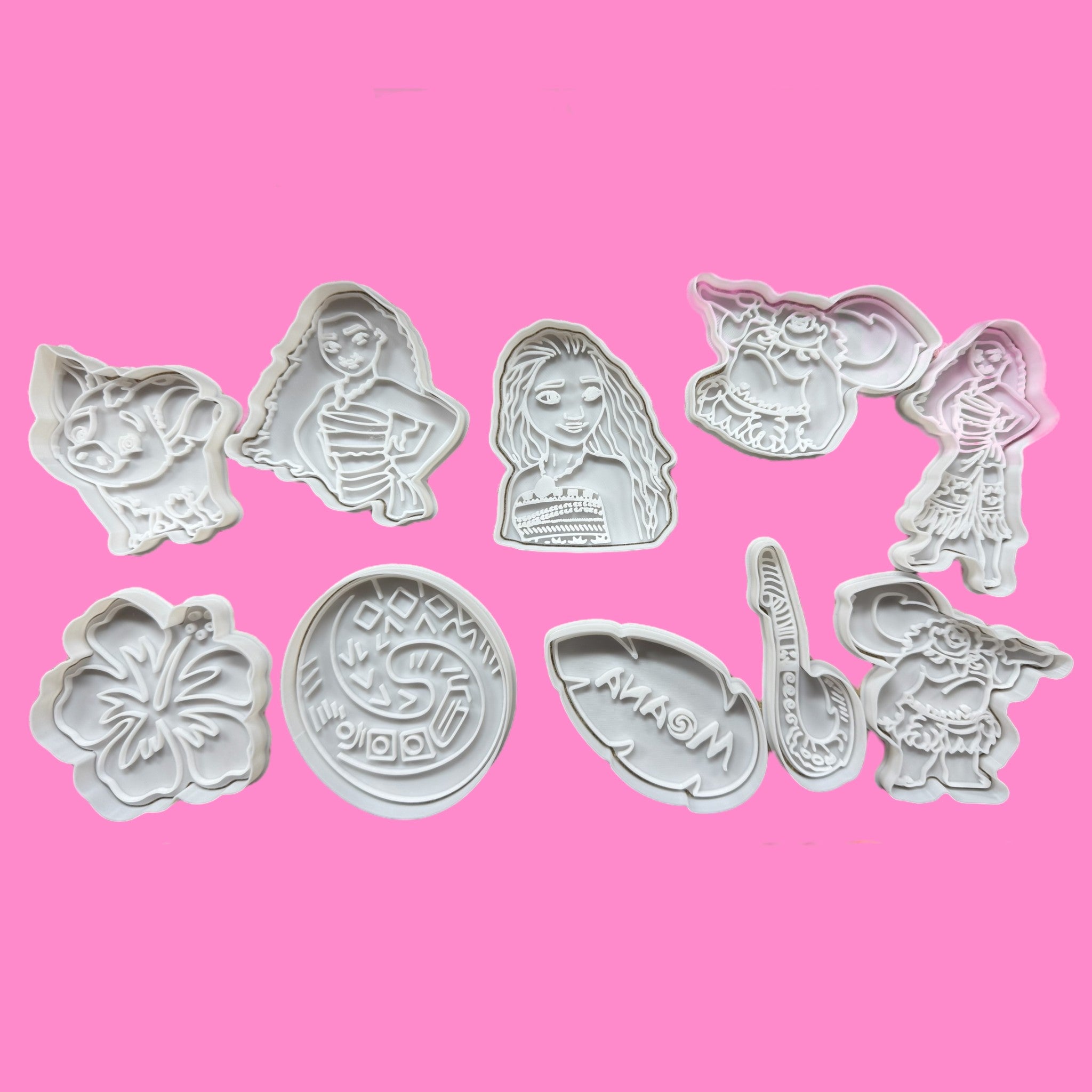 A collection of 10 Moana-inspired cookie cutters and embossers, including shapes of characters and tropical motifs, on a pink background.