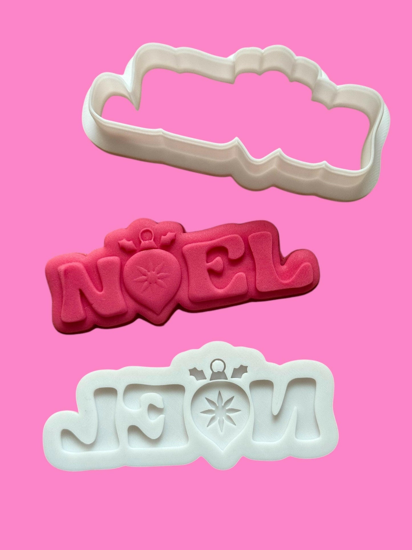 An image showcasing a multilayered 'Noel' font cookie cutter and stamp set in various colors, with the word 'NOEL' prominently displayed.