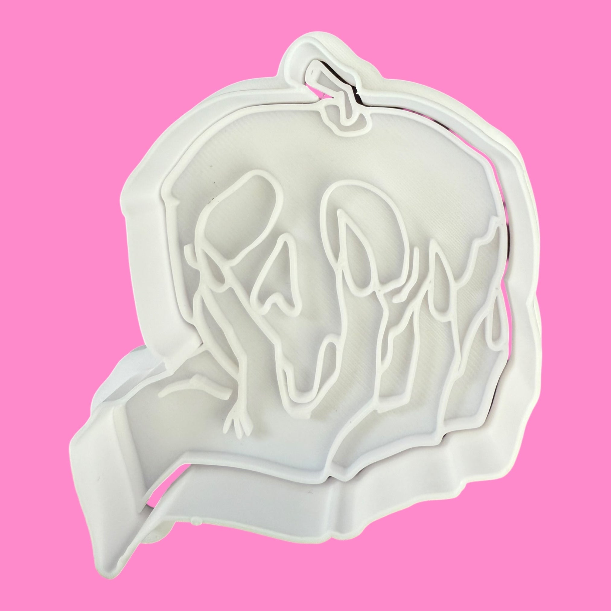White cookie cutter with a horse design on a pink background