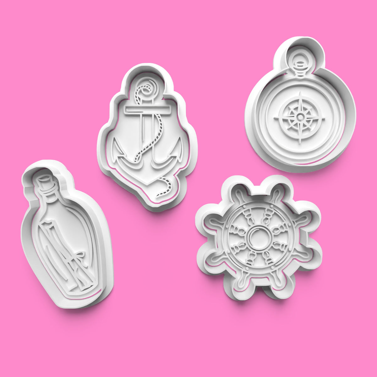 A set of four sail-themed cookie cutters and stamps, including shapes of a anchor, a compass, a sailboat, and a sailor hat, displayed on a pink background.