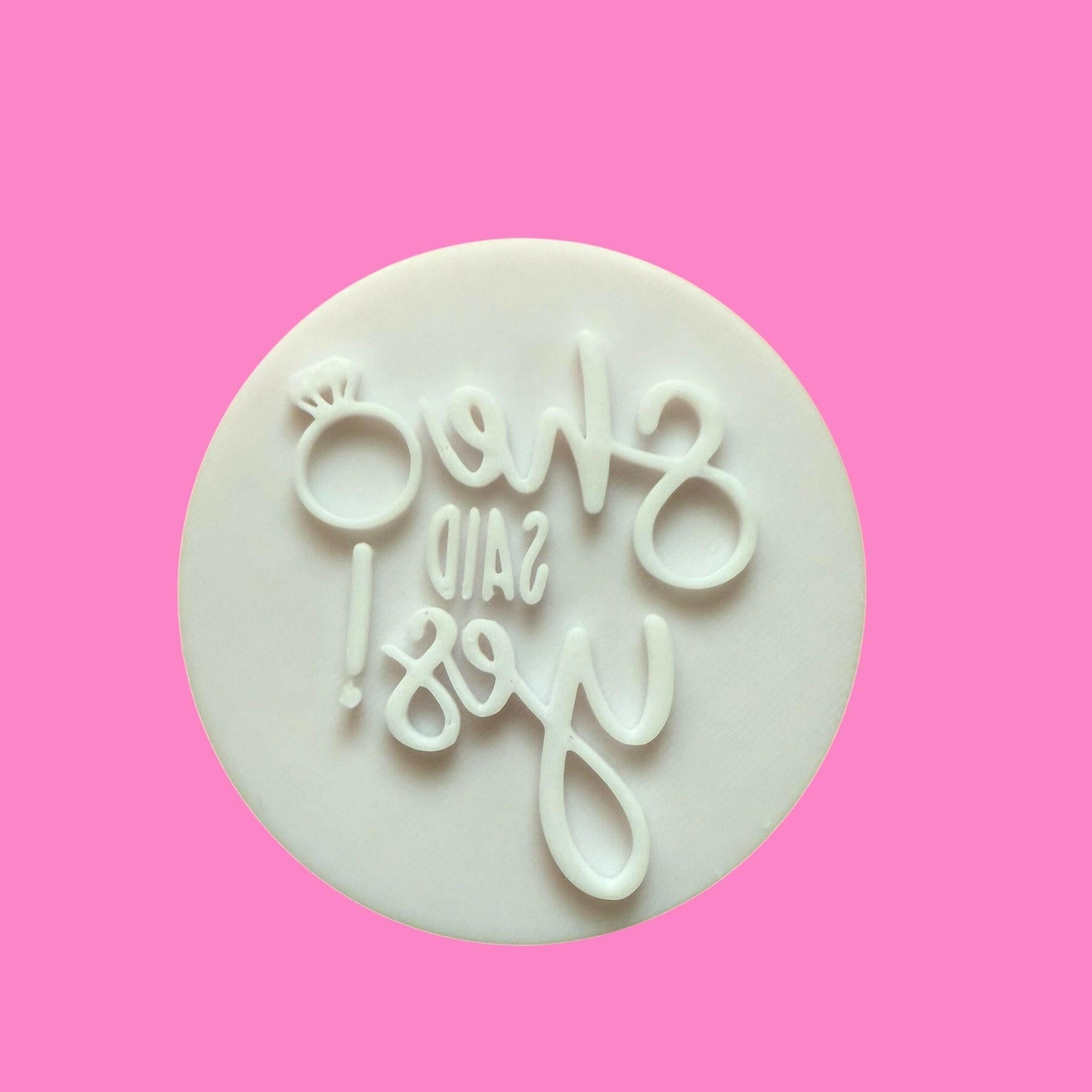 A cookie cutter and stamp set with an elegant 'I Love You' font design, shaped like a heart, made from white plastic material.
