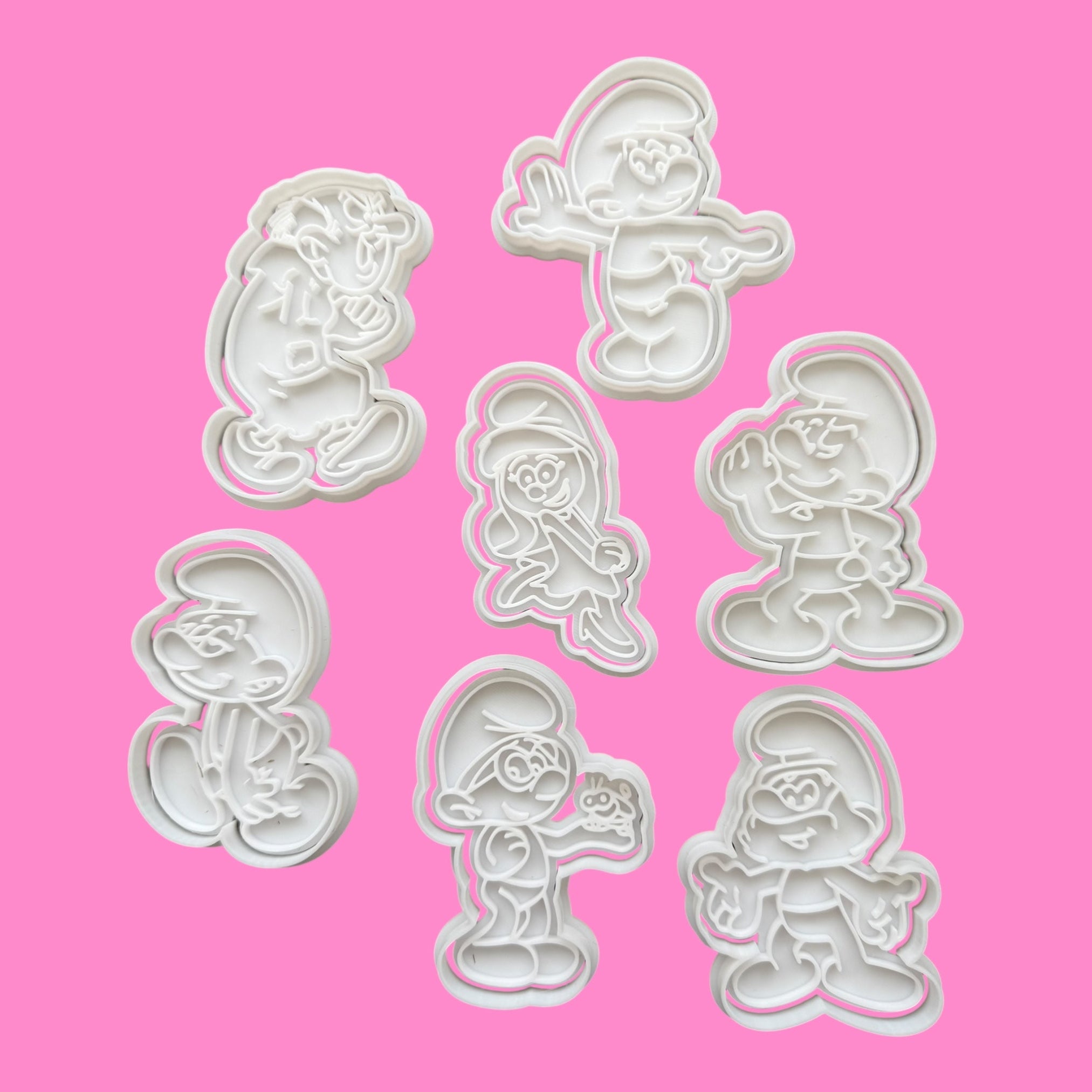 Set of Smurf cookie cutters on a pink background